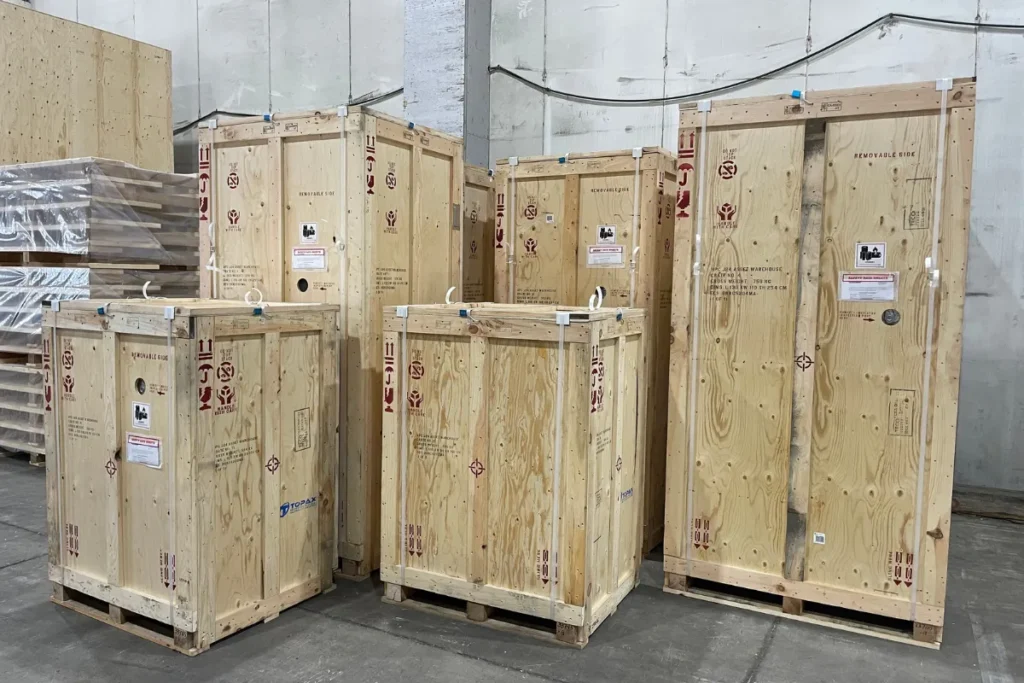Multiple wooden export crates of different sizes labeled with handling symbols and prepared for shipment