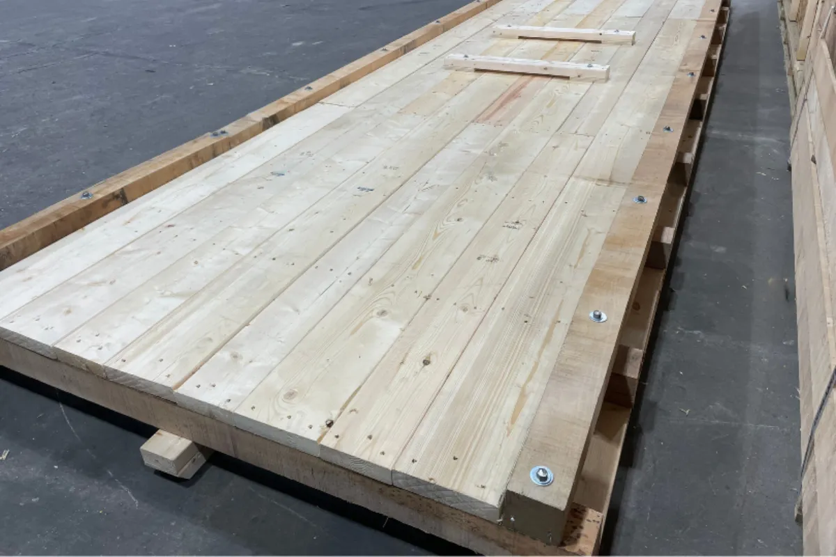 Large heavy duty wooden base platform built with thick lumber and bolts for supporting oversized equipment
